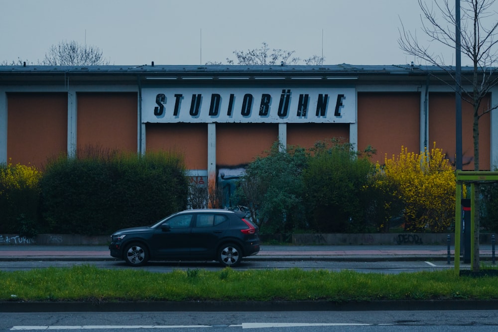 a black car parked in front of a building