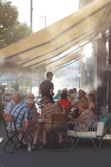 a group of people sitting around a table under a canopy