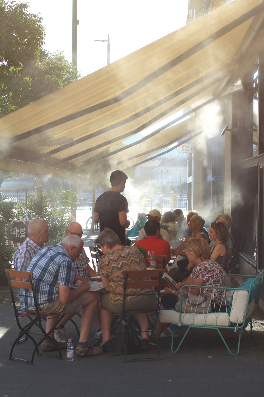 a group of people sitting around a table under a canopy