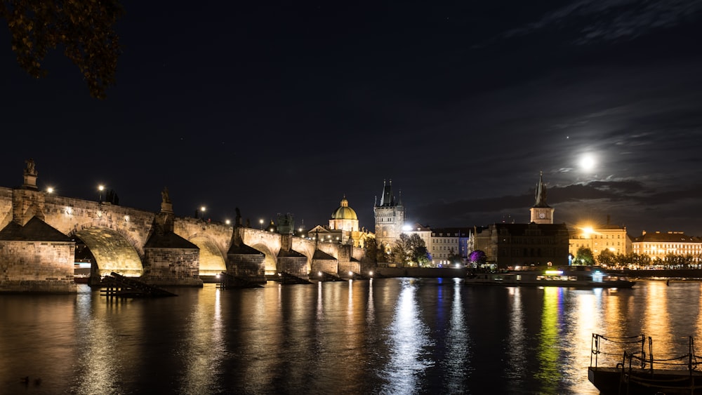 a night view of a city with a bridge over water