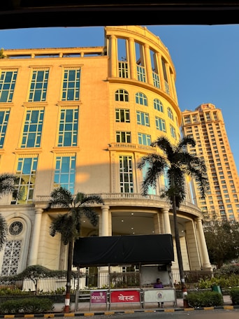 a large yellow building with palm trees in front of it