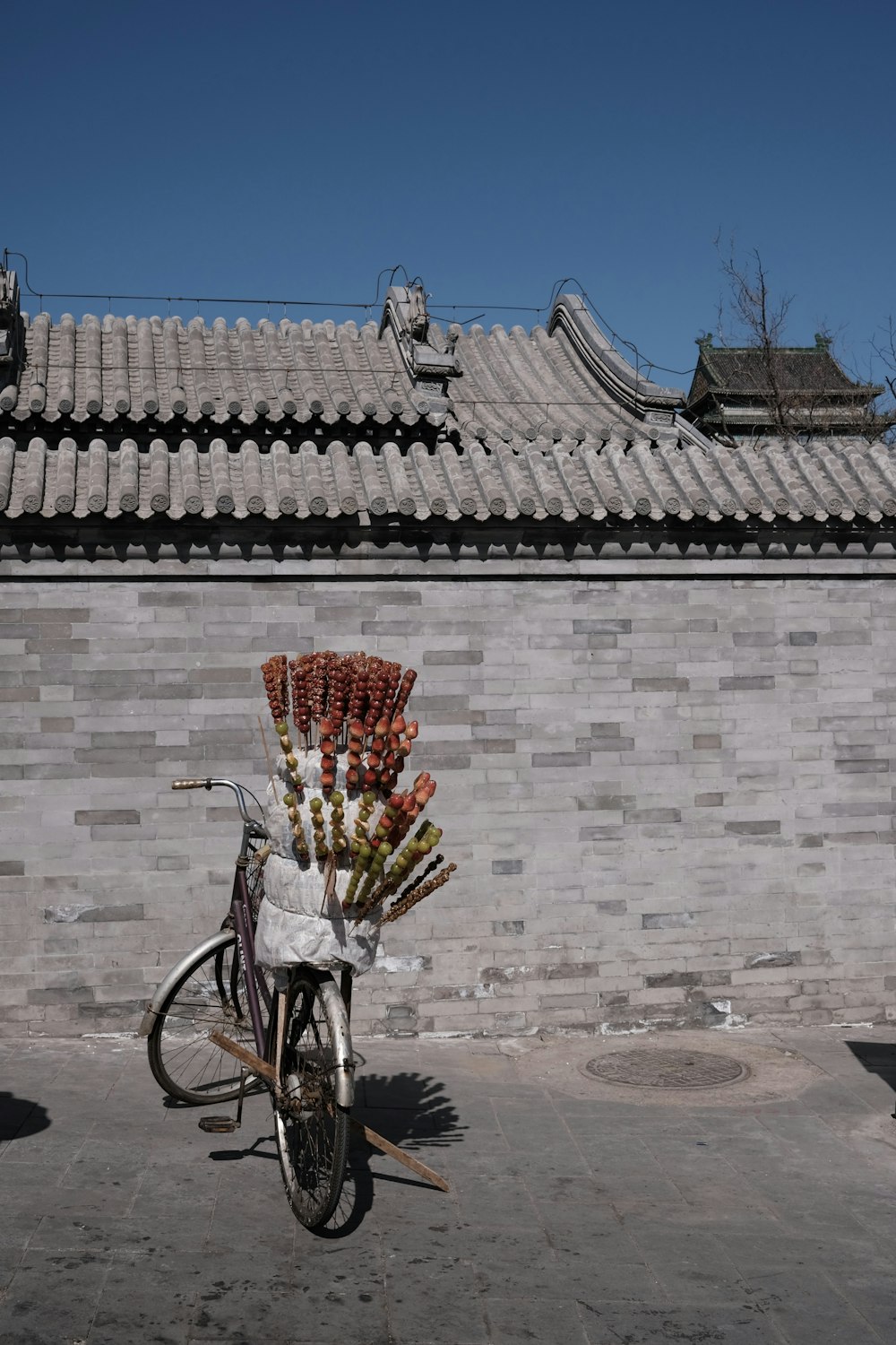 a bicycle with a basket full of flowers in front of a building