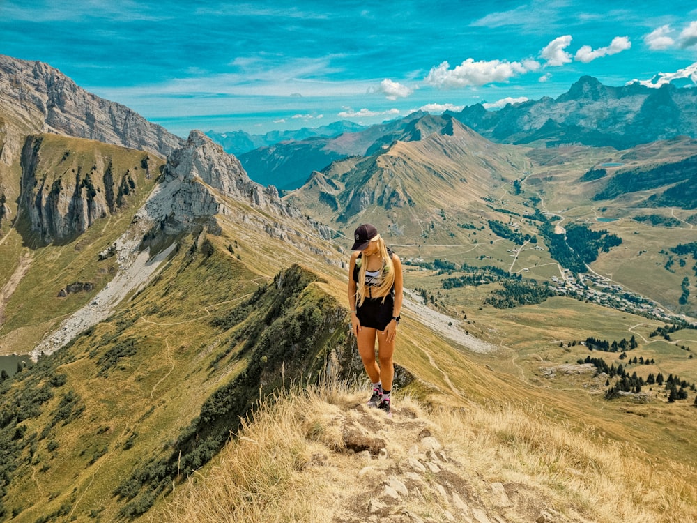 a woman is running on a trail in the mountains