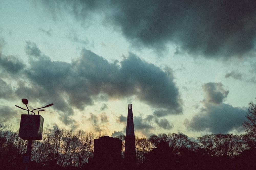 a view of a cloudy sky with a clock tower in the foreground