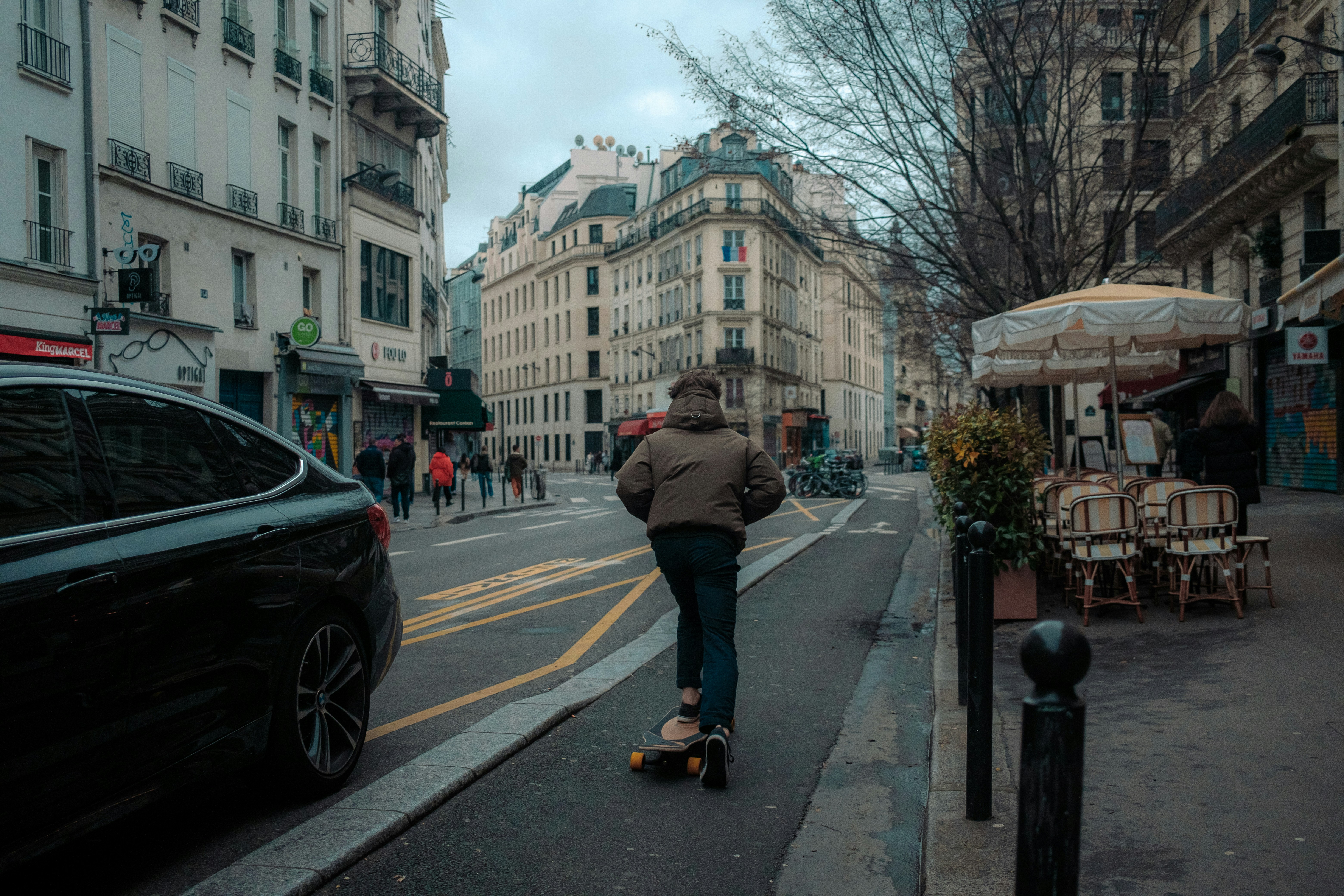 a man riding a skateboard down a city street, 