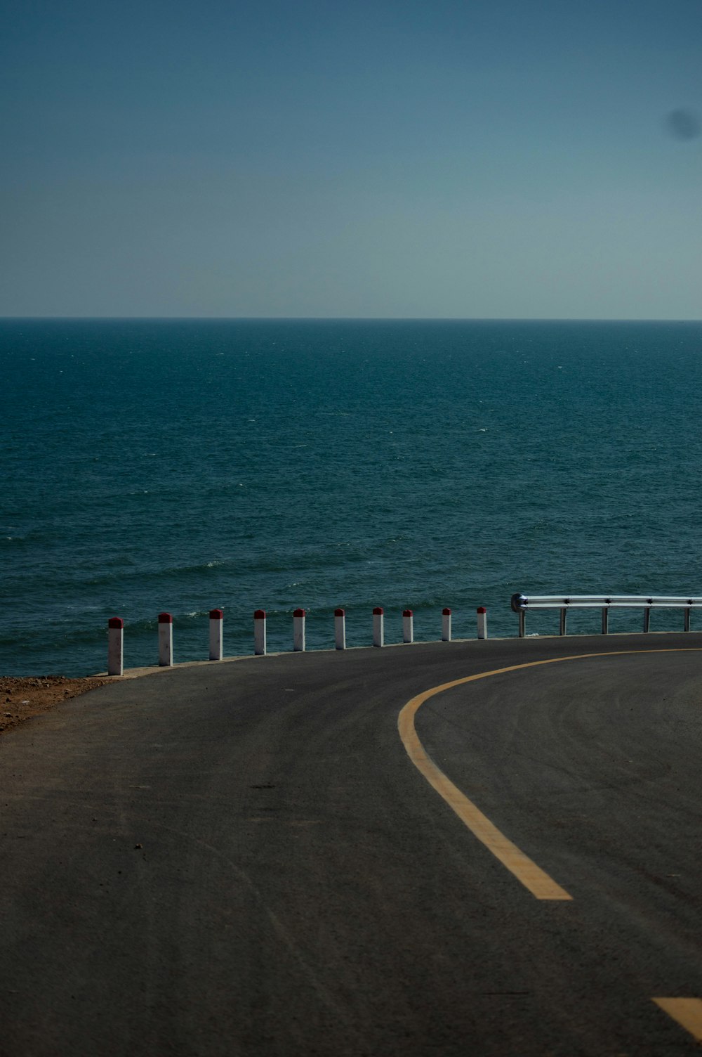 a curved road next to a body of water