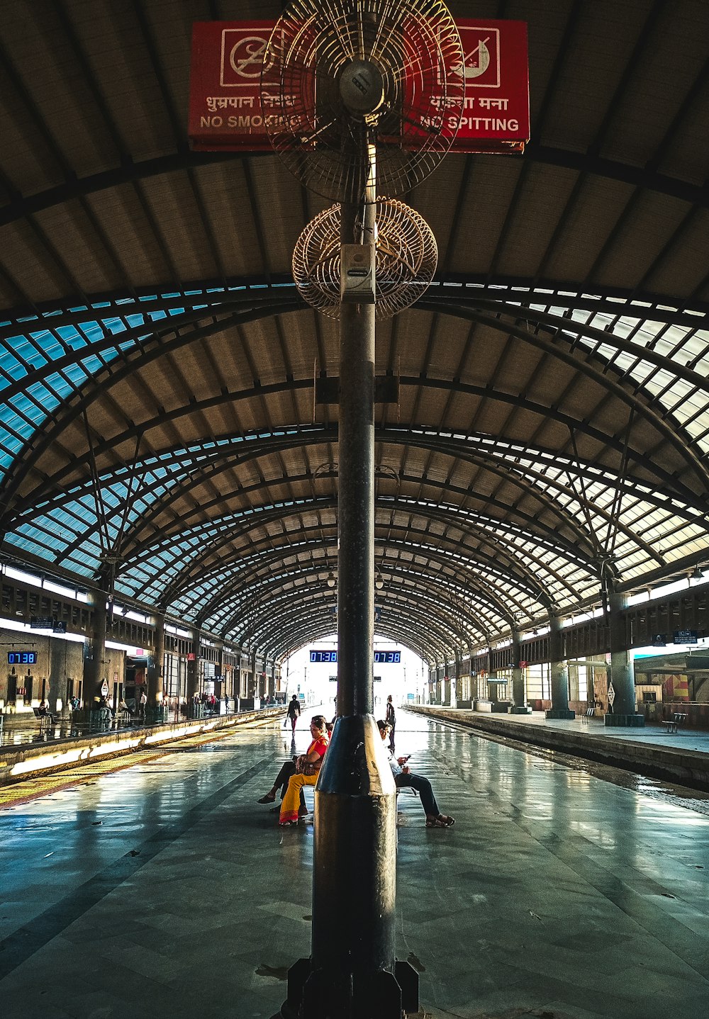 a train station with people sitting on benches