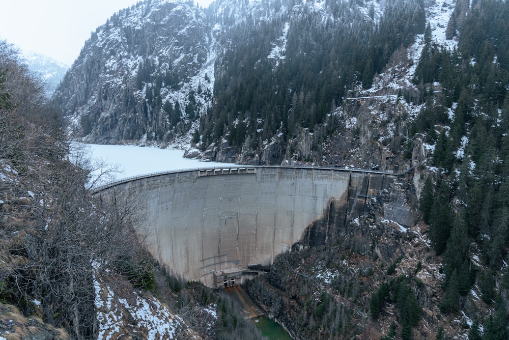 a large dam in the middle of a snowy mountain