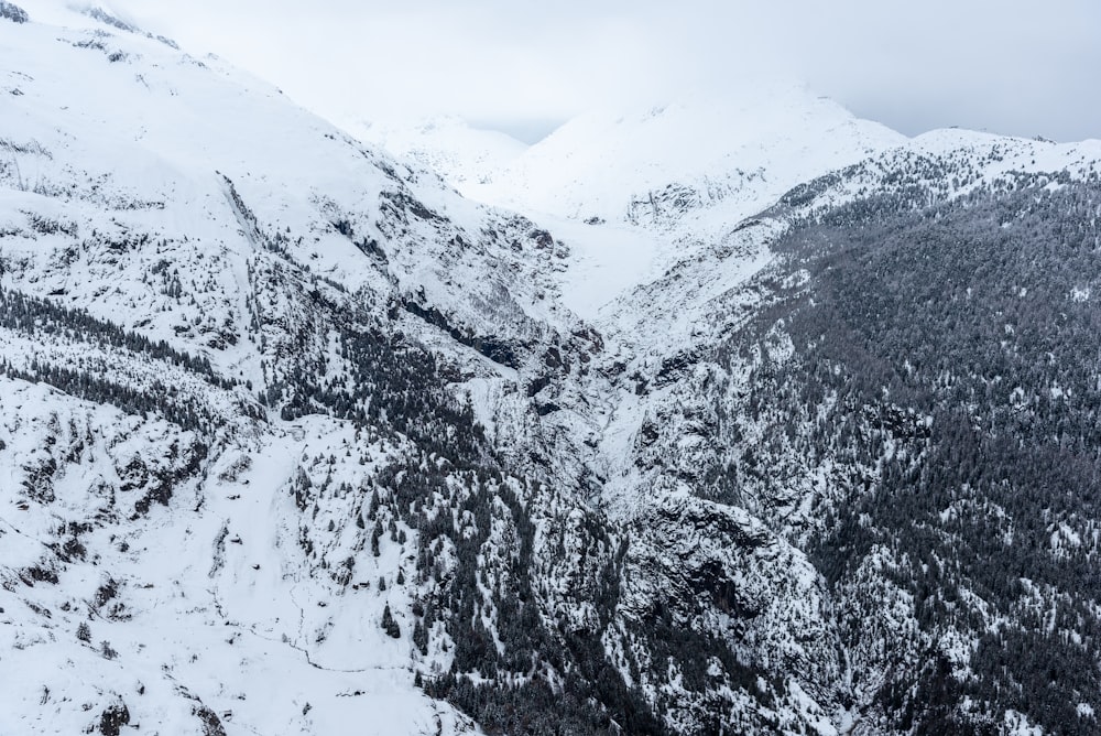 a snow covered mountain with a train going through it