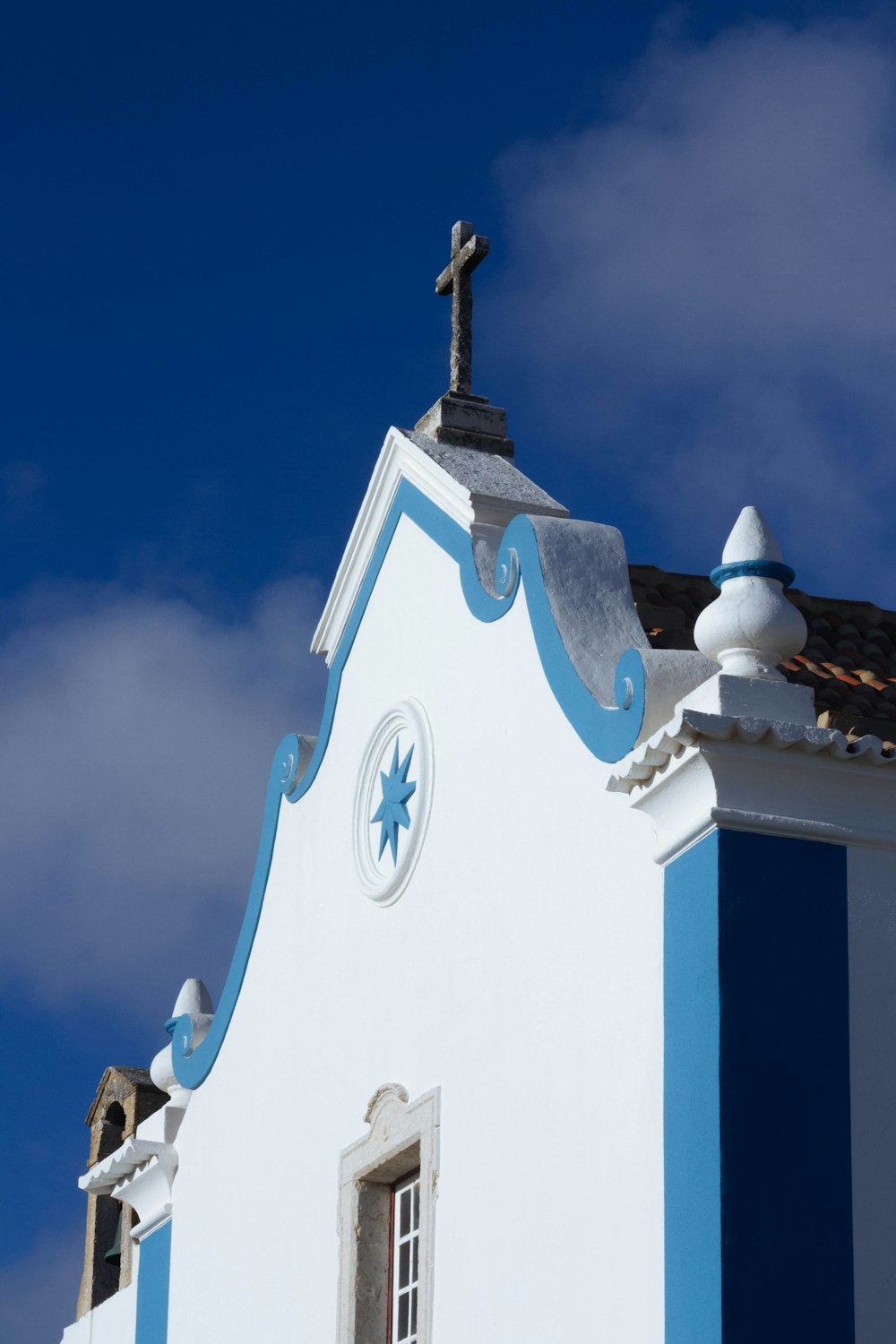 um edifício azul e branco com uma cruz no topo