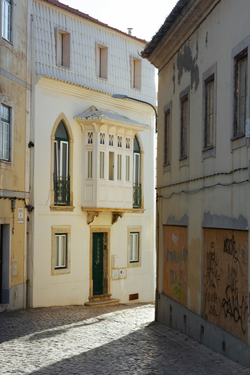 un vecchio edificio con una porta e finestre verdi