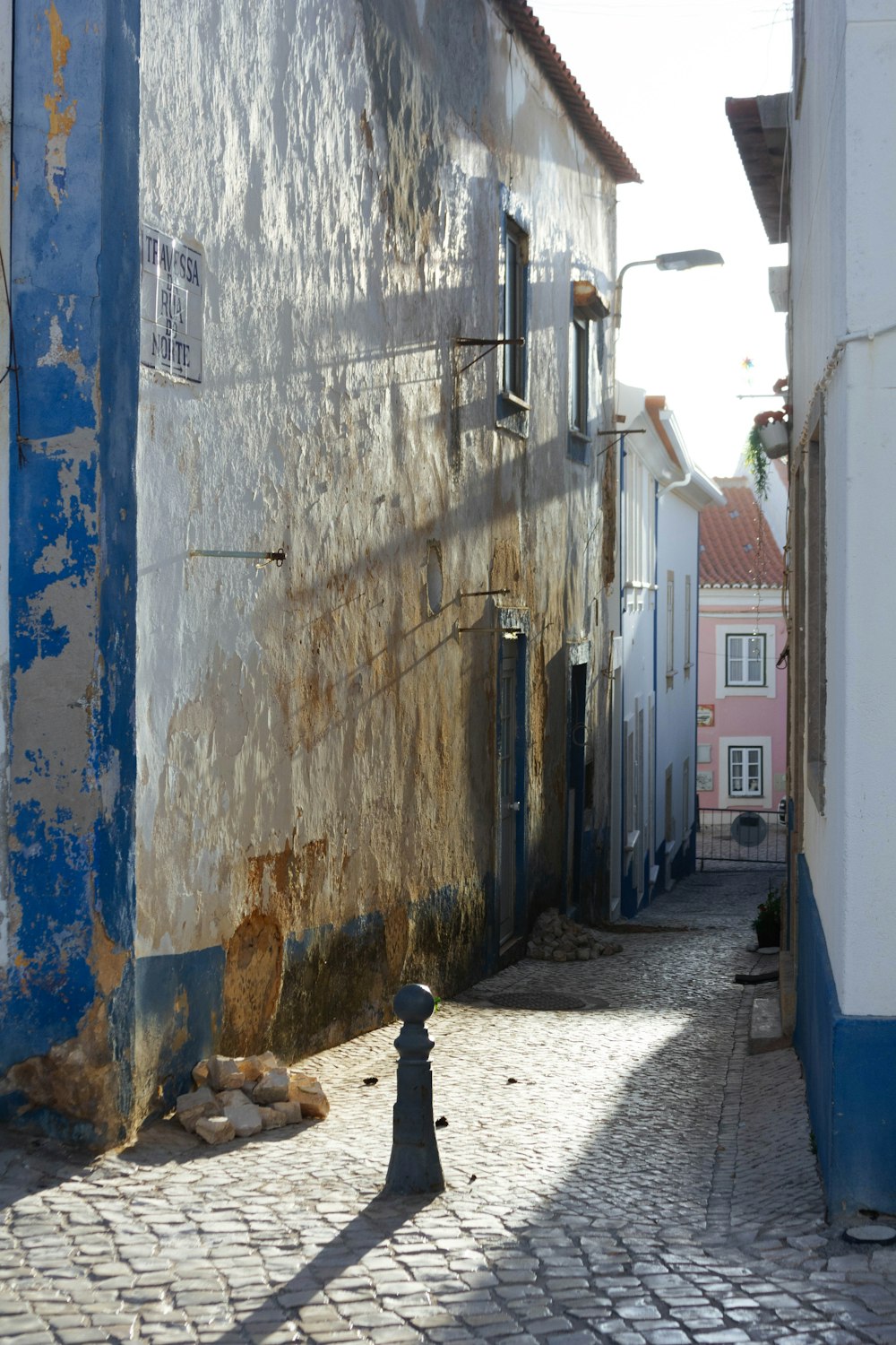 a street with a blue and white building and a black fire hydrant