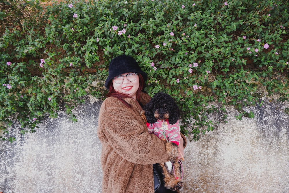 a woman holding a small dog in her arms