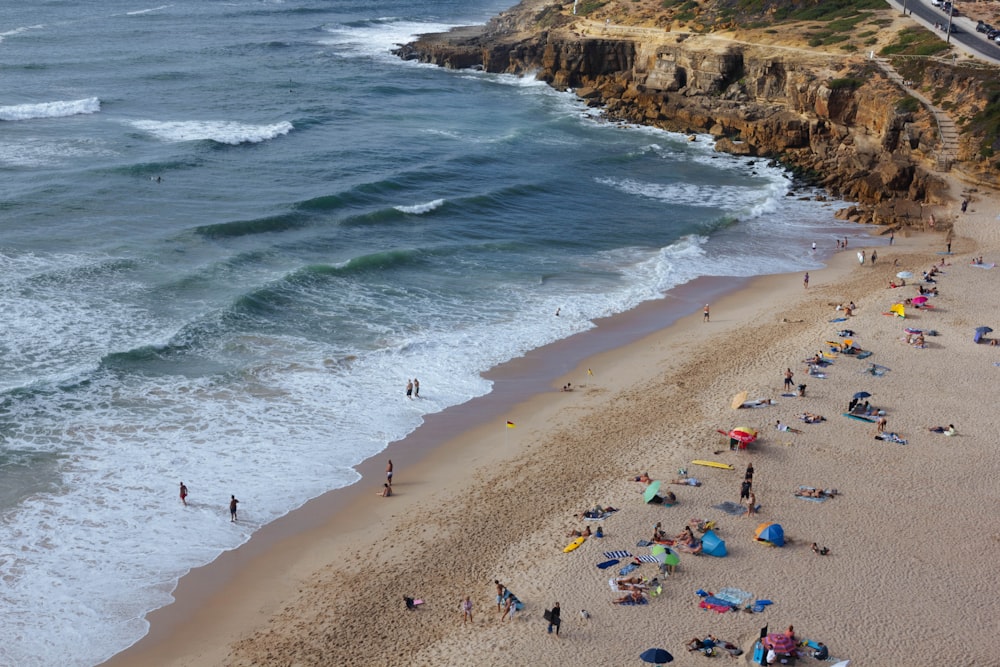 Un grupo de personas de pie en la cima de una playa junto al océano