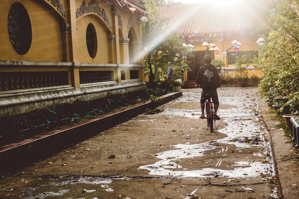 a man riding a bike down a dirt road