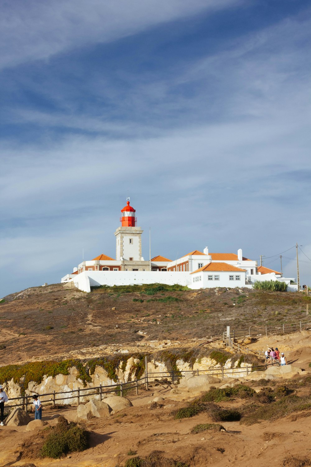 a lighthouse on top of a hill with a sky background