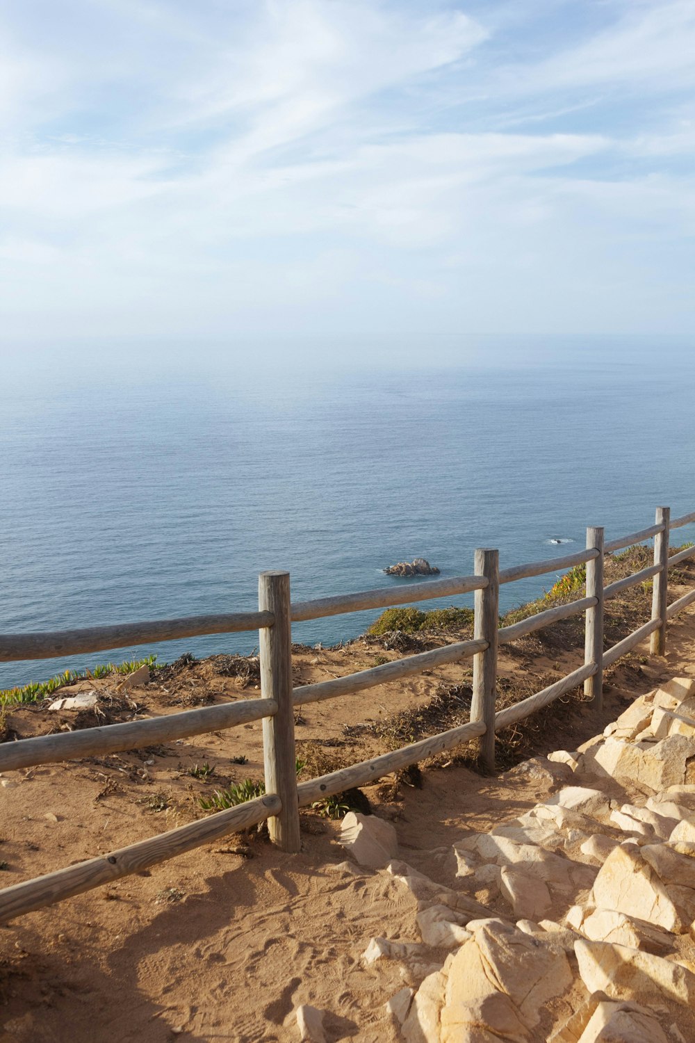 a wooden bench sitting on top of a sandy beach