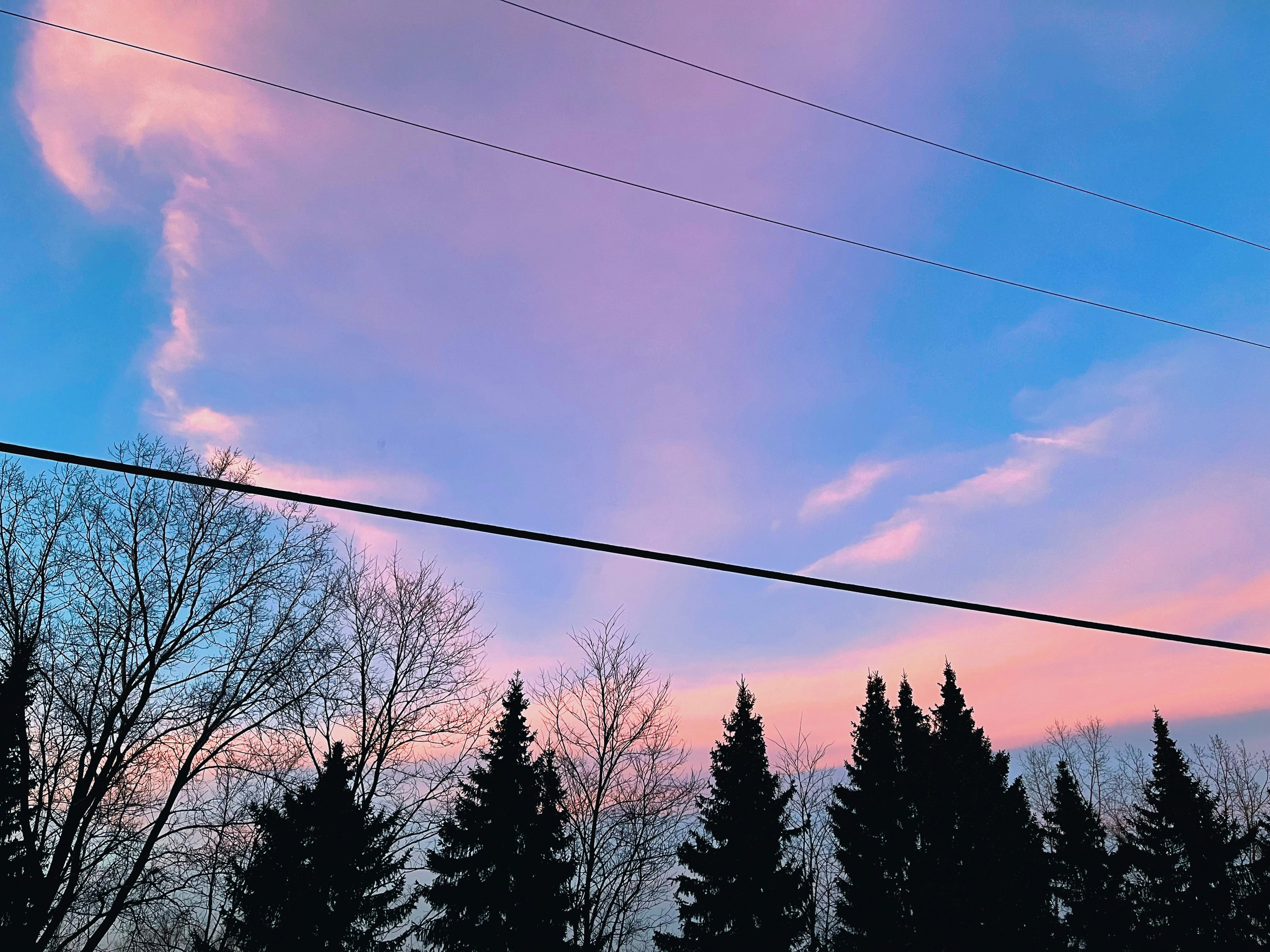 the sky is pink and blue as the sun sets
