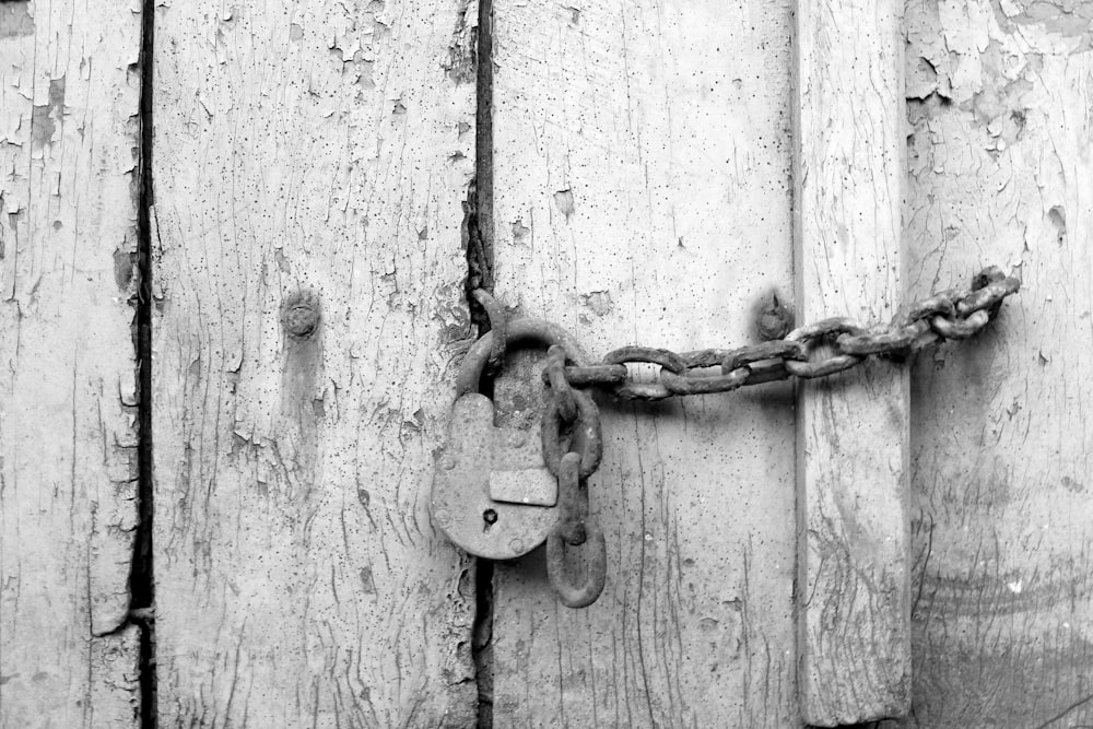 uma fechadura e corrente em uma porta de madeira