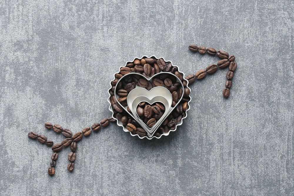 a heart shaped container filled with coffee beans