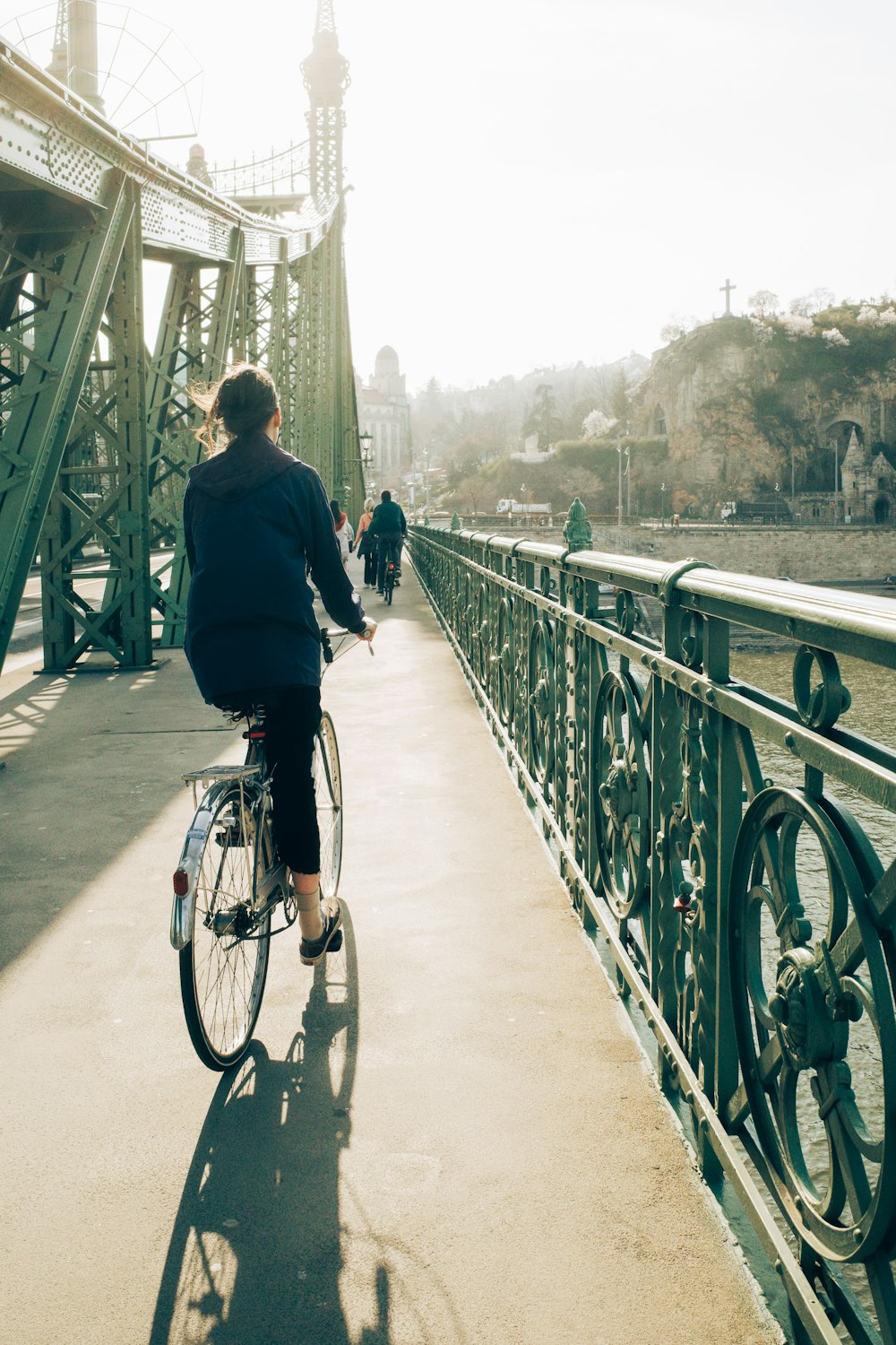 a person riding a bike across a bridge