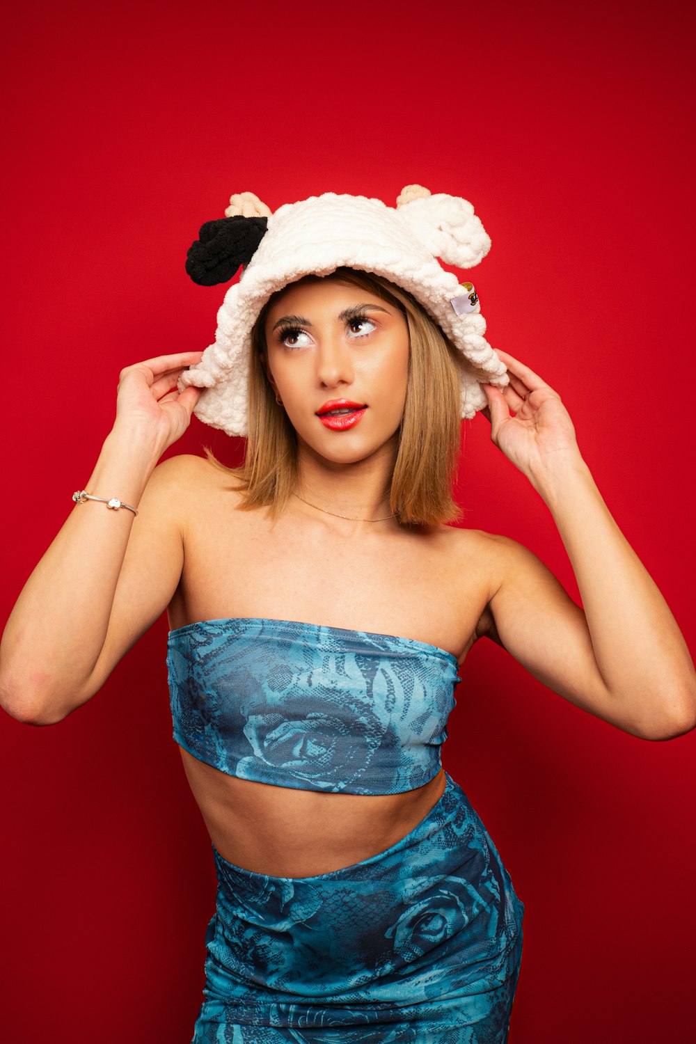 a woman in a blue dress and a sheep hat