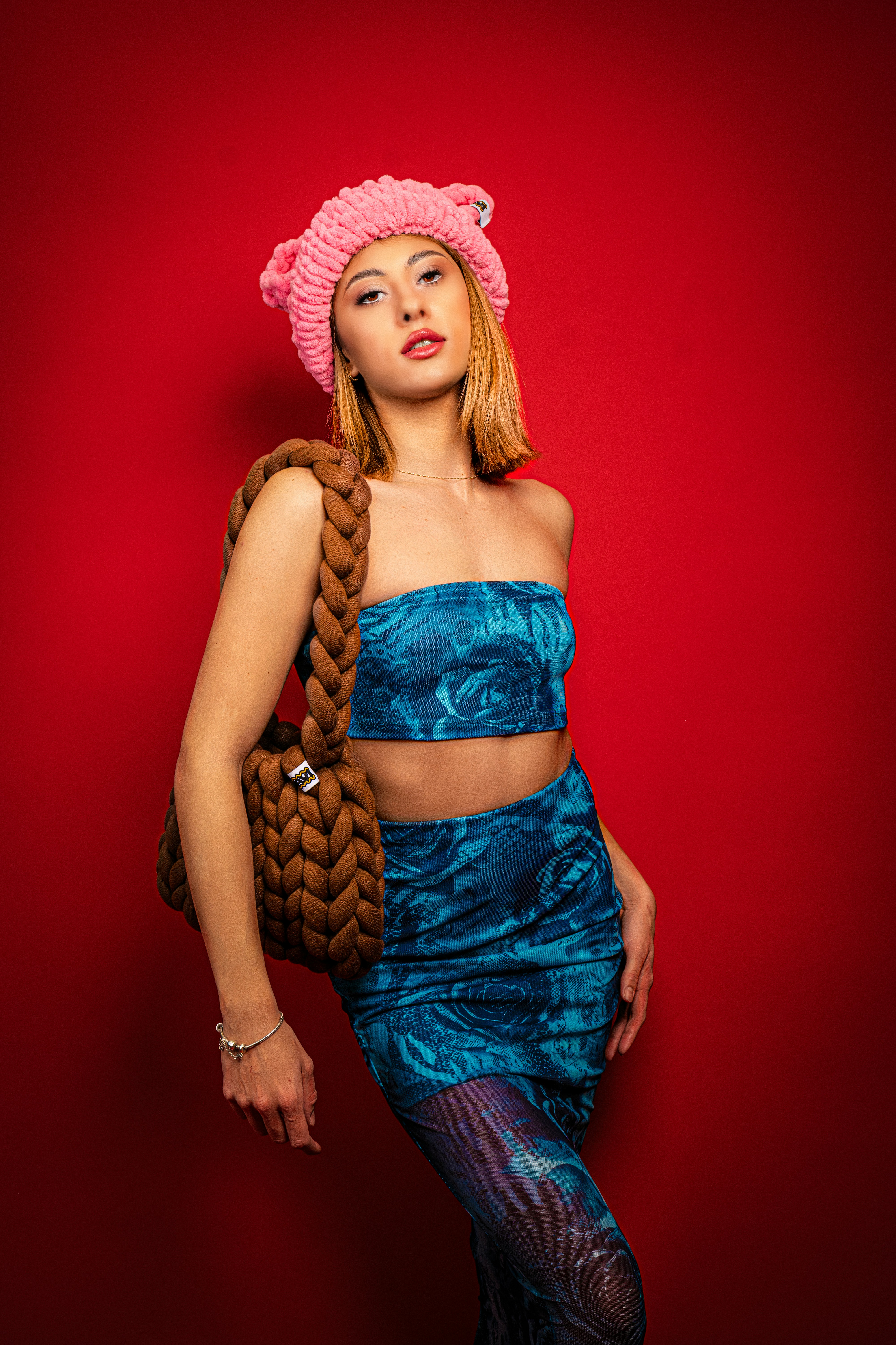 una donna con un vestito blu e un cappello rosa