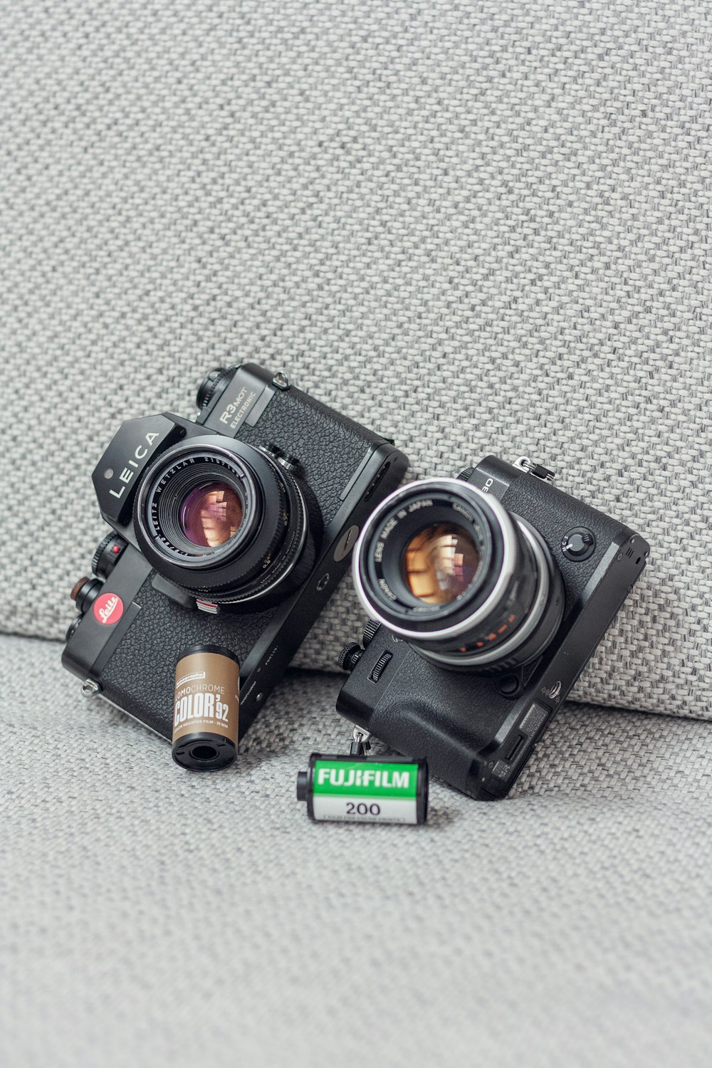 a couple of cameras sitting on top of a couch