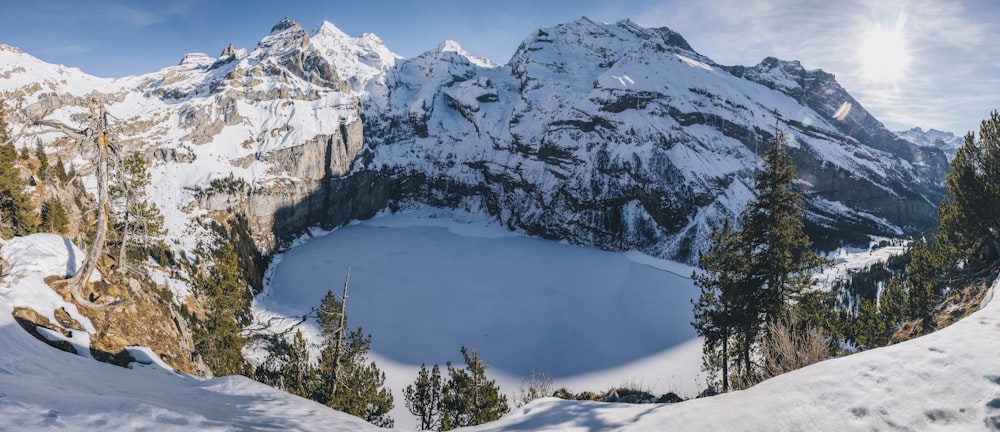 a snow covered mountain with a lake surrounded by trees