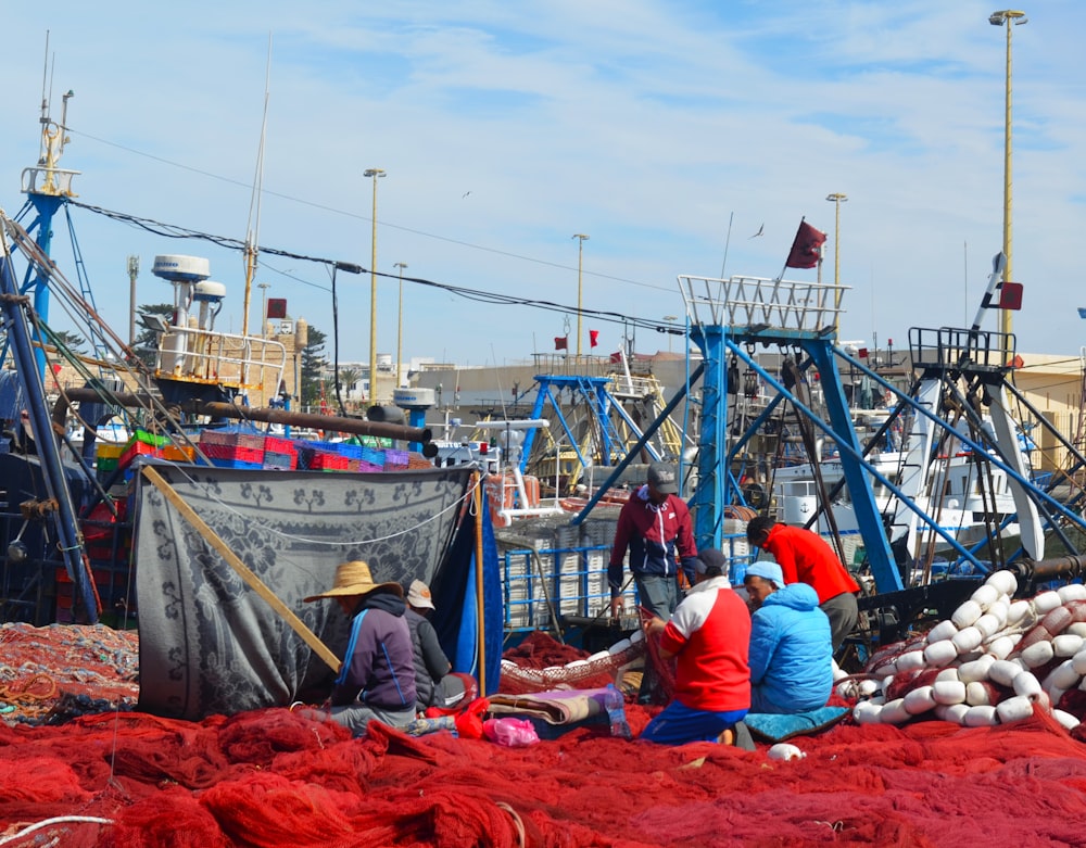 a group of people sitting on top of a pile of red stuff