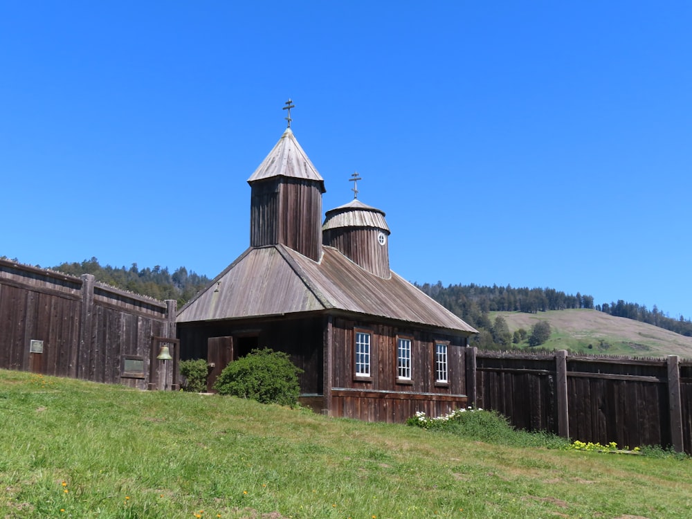 an old wooden church with a steeple on a hill