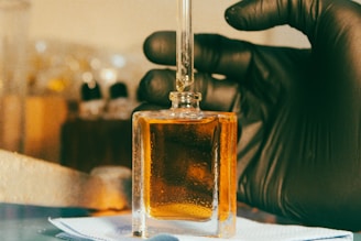 a gloved hand is holding a bottle of liquid