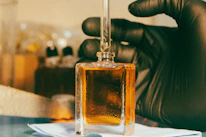 a gloved hand is holding a bottle of liquid