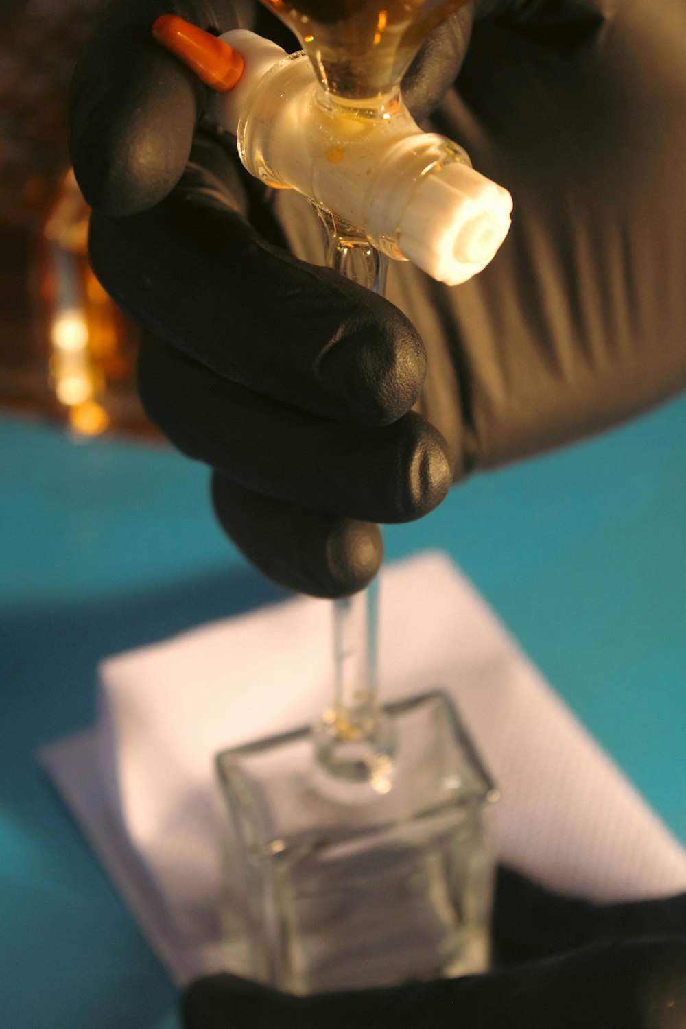 a person holding a small glass with a liquid in it