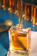 a small square bottle of oil sitting on top of a table