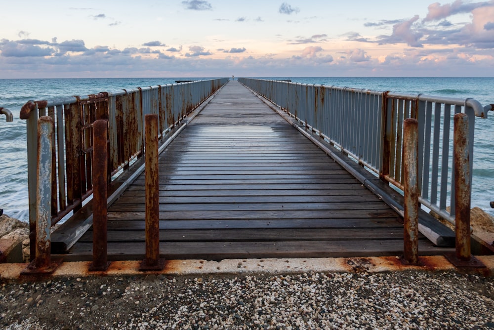 a rusty metal bridge over a body of water