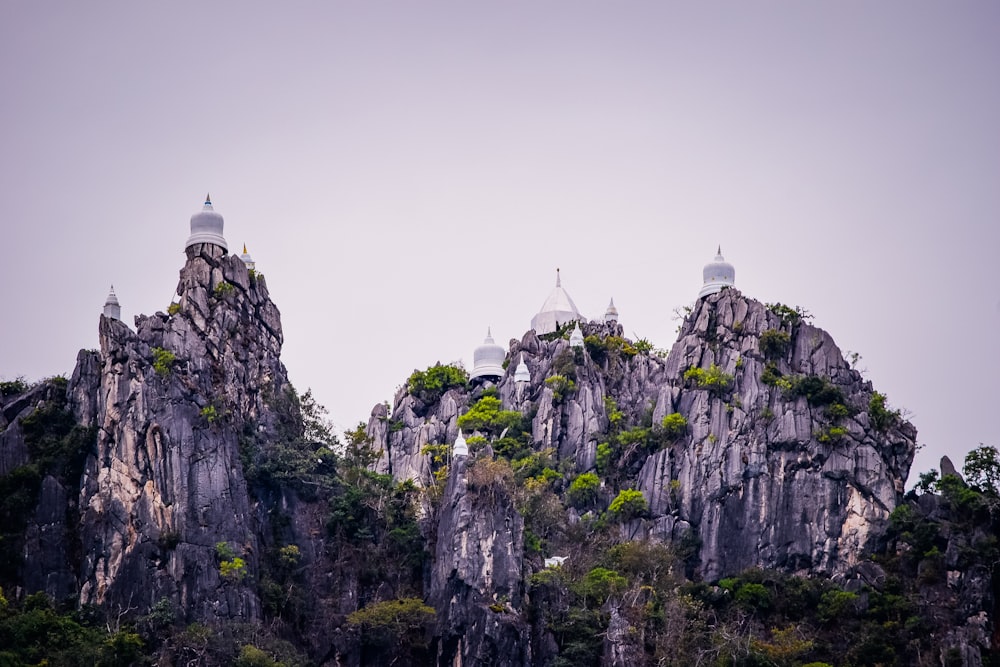 a group of rocks sitting on top of a lush green hillside