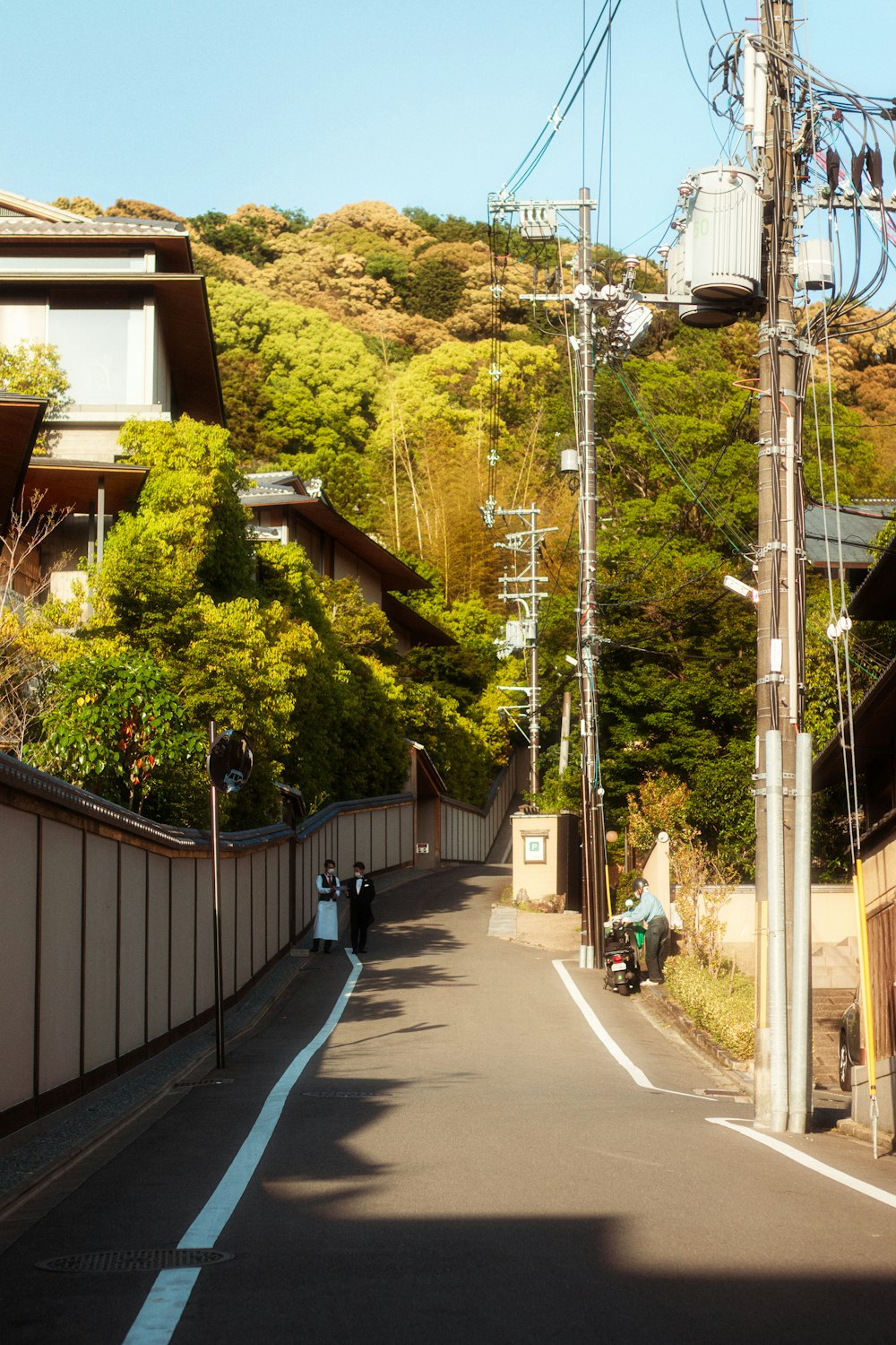a narrow street with power lines above it