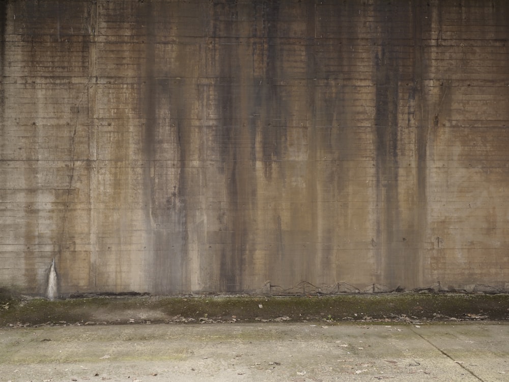 a person sitting on a bench in front of a wall