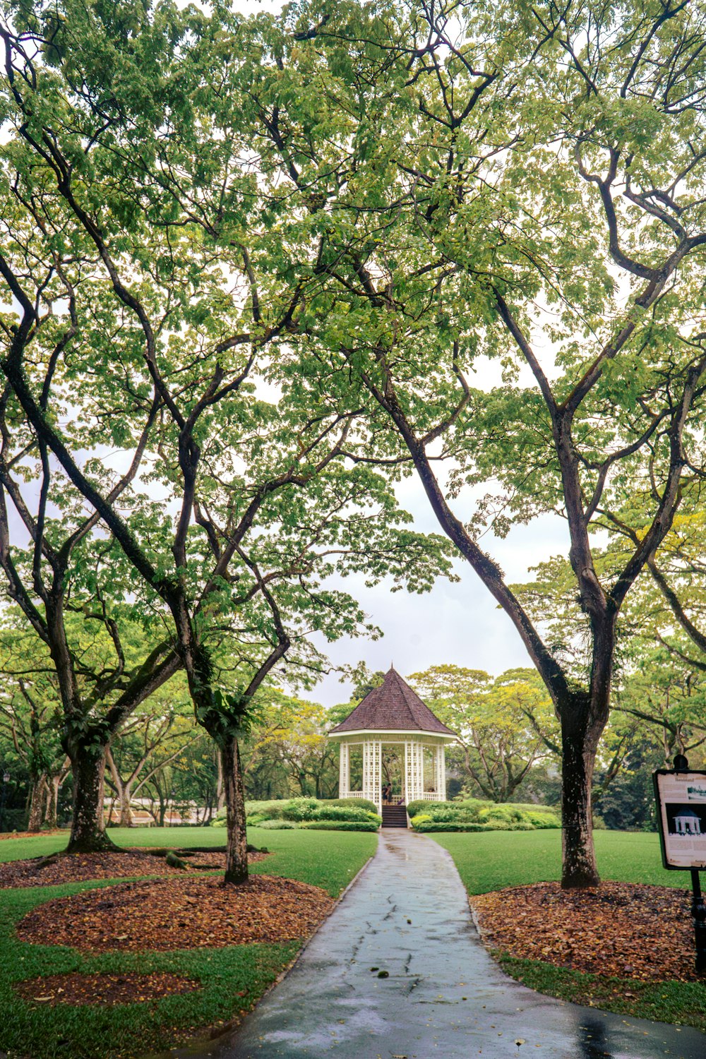 a gazebo in the middle of a park surrounded by trees