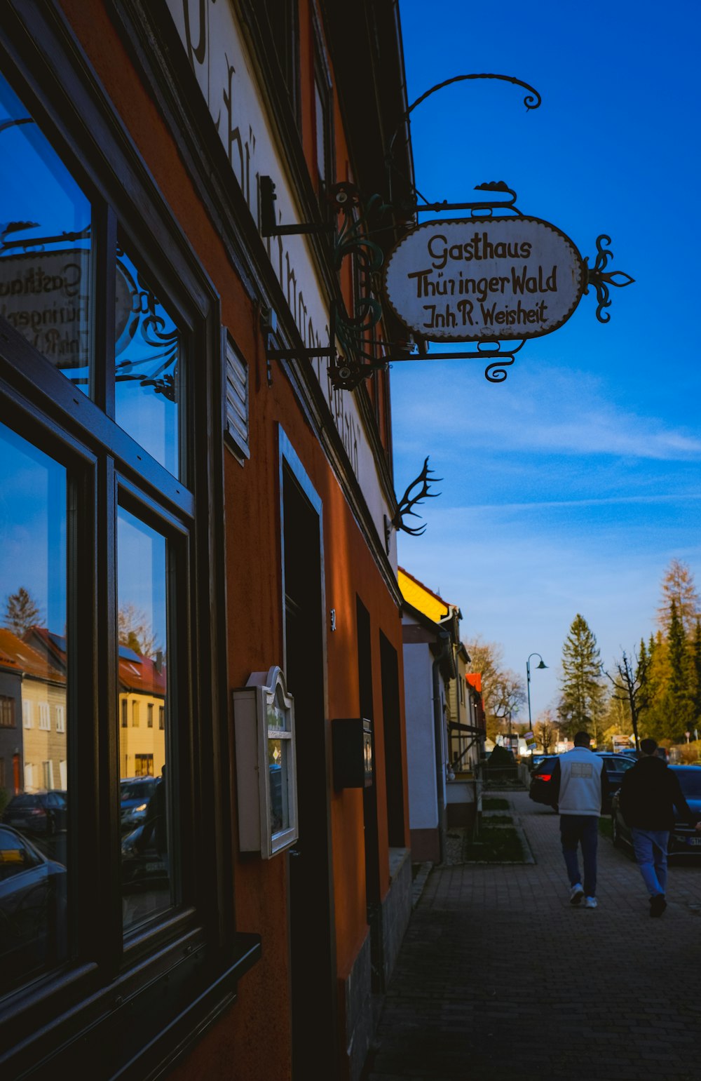 a person walking down a sidewalk past a building