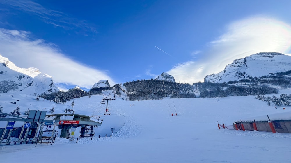 a snow covered ski slope with mountains in the background