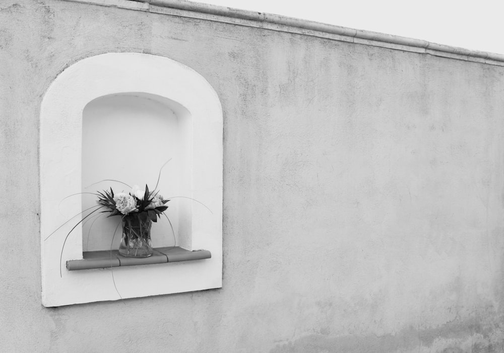 a vase with flowers in it sitting on a window sill