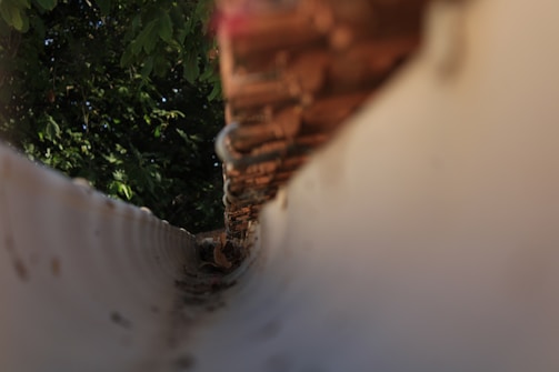 a close up of a fence with trees in the background