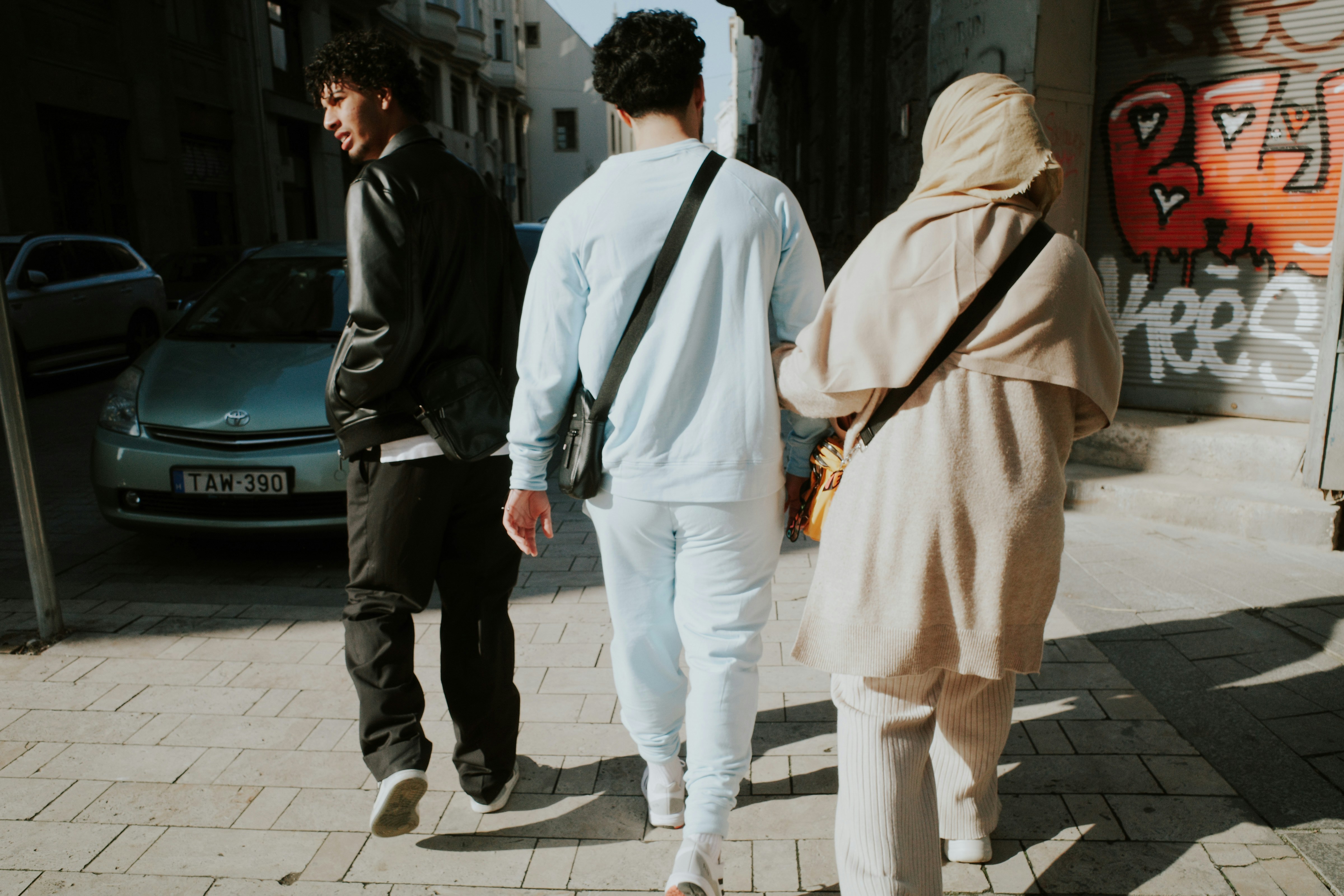 a group of people walking down a sidewalk