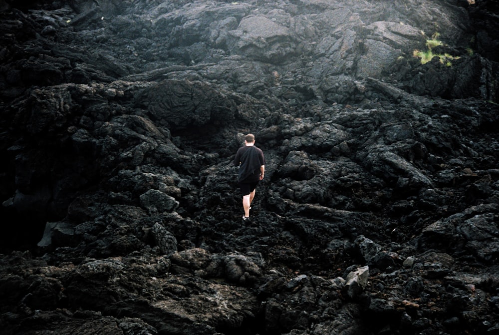 a man standing in the middle of a rocky area