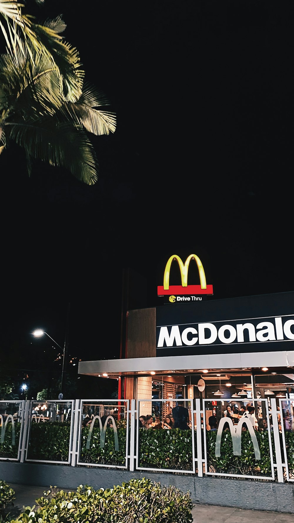 a mcdonald's restaurant with a palm tree in the background