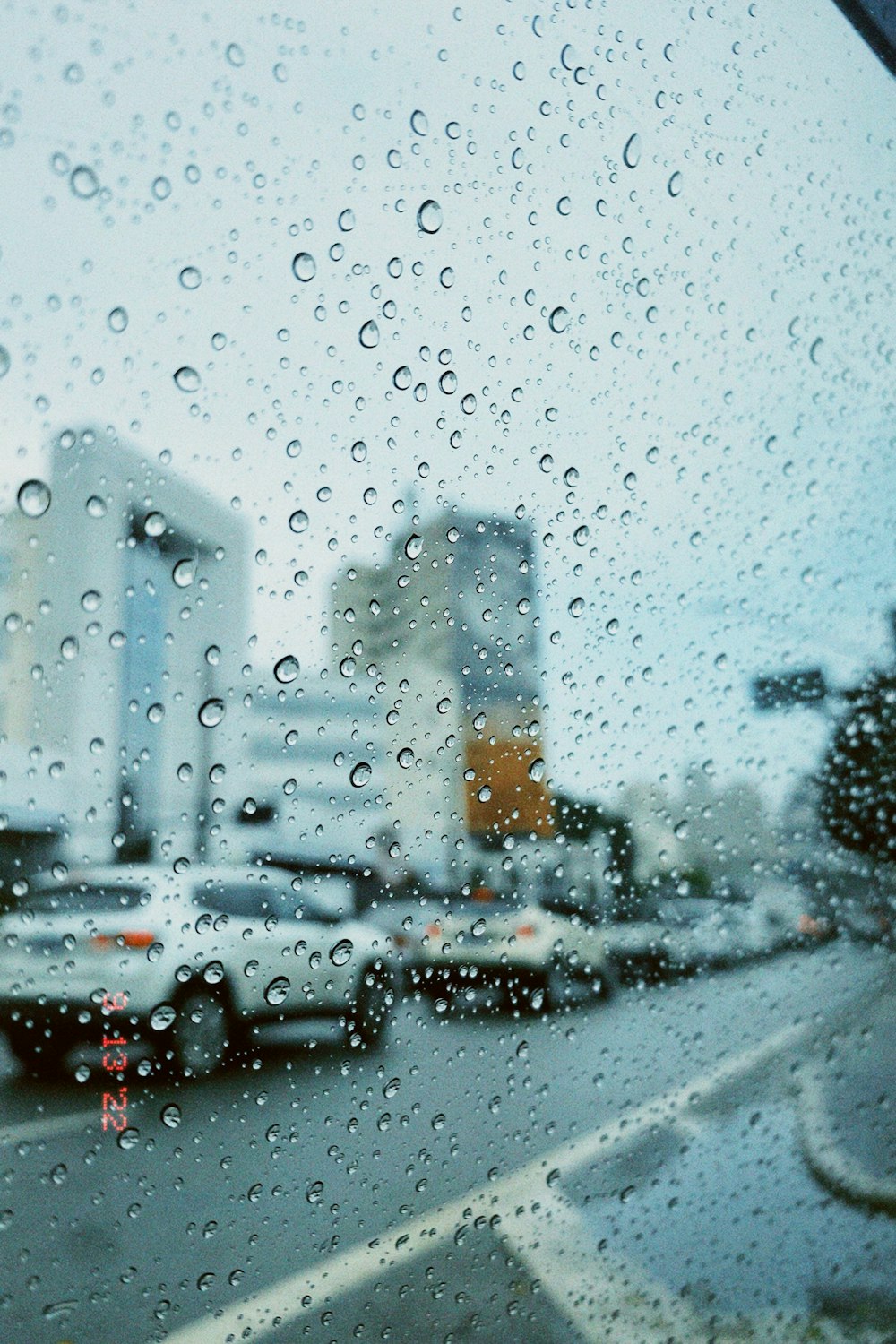 a view of a city through a rain covered window
