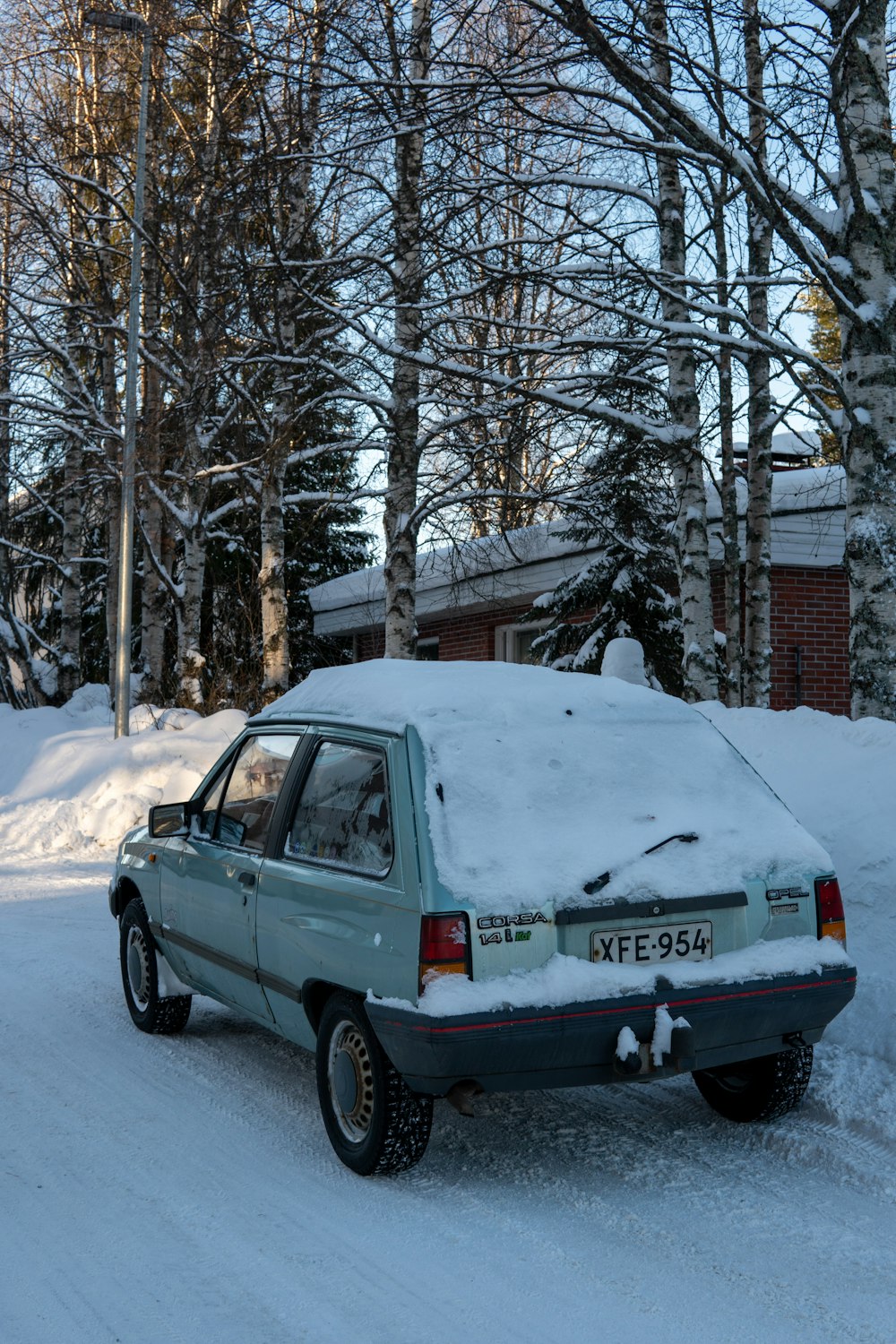 a car covered in snow parked on the side of a road