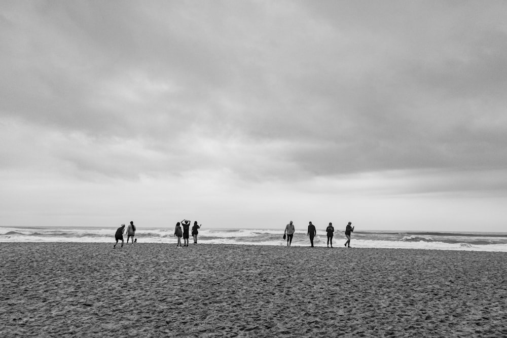 a group of people standing on top of a sandy beach